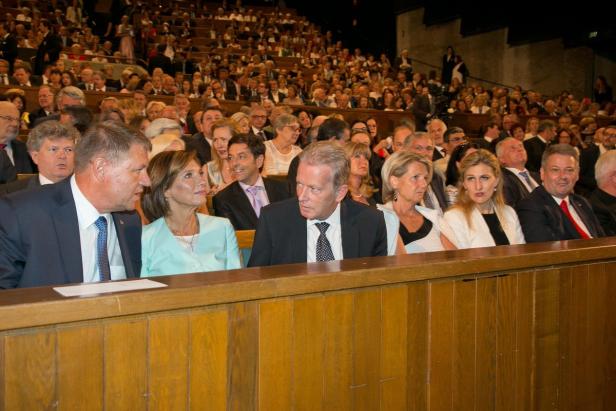 Zuschauer sitzen bei einer Veranstaltung in einem vollbesetzten Saal.