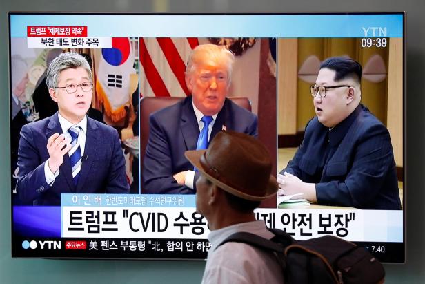 A man walks past a TV broadcasting a news report on the upcoming dismantling of the Punggye-ri nuclear testing site, in Seoul
