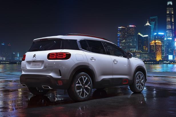 Ein weißer Citroën C5 Aircross vor der Skyline einer Großstadt bei Nacht.