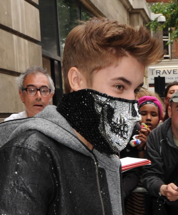 Justin Bieber trägt eine Totenkopfmaske vor einem Gebäude.