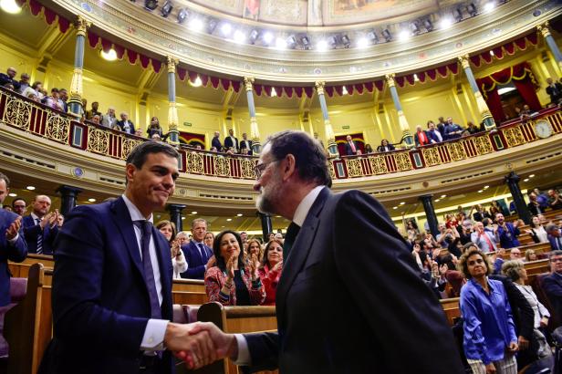 Spain's new Prime Minister and Socialist party (PSOE) leader Pedro Sanchez shakes hands with ousted Prime Minister Mariano Rajoy after a motion of no confidence vote at parliament in Madrid