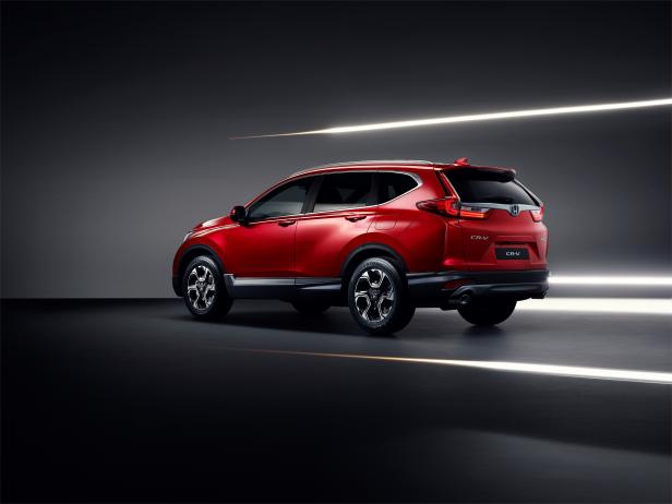 Ein roter Honda CR-V steht in einem dunklen Studio.