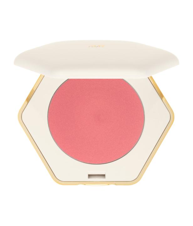 Ein geöffneter, sechseckiger Rouge-Puder in einer elfenbeinfarbenen und goldenen Dose.