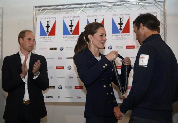 Kate Middleton überreicht einem Segler eine Louis Vuitton America's Cup Medaille, während Prinz William applaudiert.