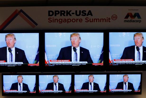 A TV news reports about U.S. President Donald Trump is projected on TV sets at a media center for the summit between the U.S and North Korea in Singapore