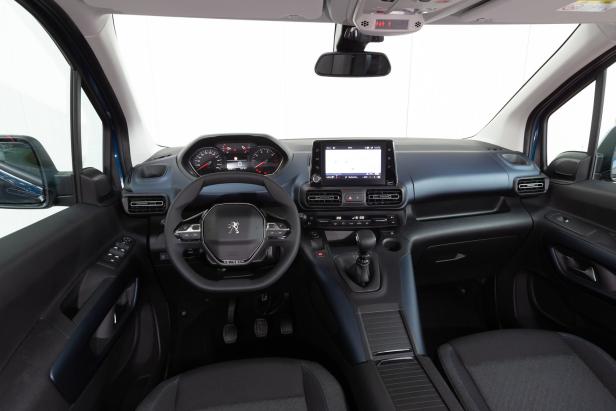 Das Interieur eines Peugeot-Fahrzeugs mit Blick auf das Armaturenbrett und das Lenkrad.