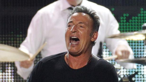 Bruce Springsteen singt während eines Konzerts mit einem Schlagzeuger im Hintergrund.