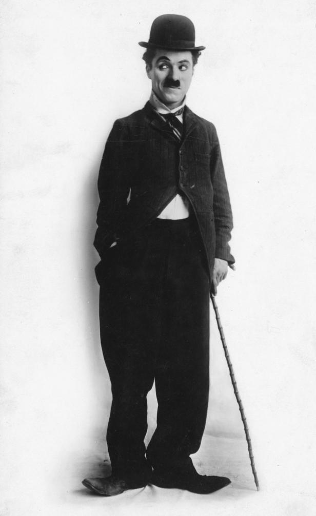 Charlie Chaplin in seinem berühmten Kostüm mit Melone und Stock.