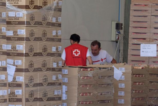 Red Cross volunteers store food at the logistical center a day before the arrival of refugee vessel Aquarius and two other Italian ships at the port of Valencia
