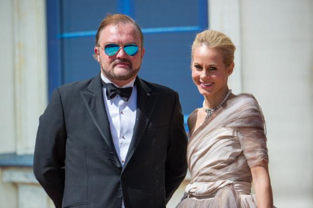 Ein Mann im Smoking und eine Frau im Abendkleid posieren für ein Foto.