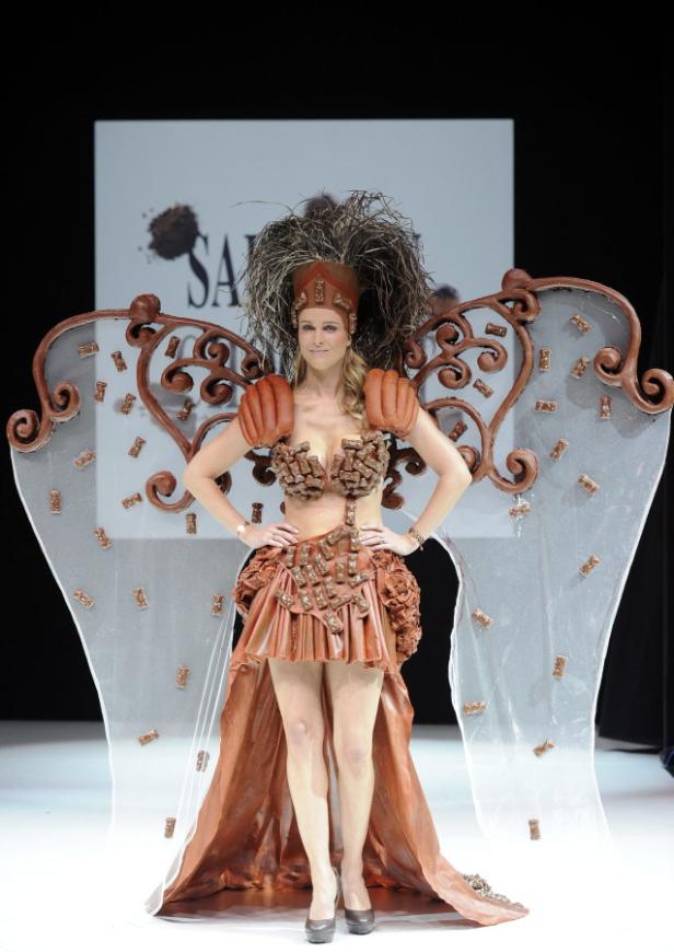 Eine Frau präsentiert ein aufwendiges Kleid aus Schokolade auf einer Modenschau.