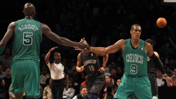 Zwei Basketballspieler der Boston Celtics geben sich während eines Spiels die Hand.