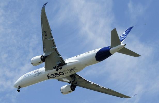 Ein Airbus A350 XWB steigt in den blauen Himmel auf.