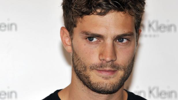 Porträt des Schauspielers Jamie Dornan vor einem weißen Hintergrund.