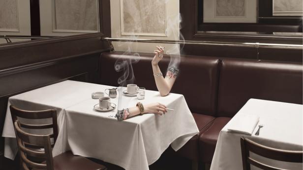 In einem Restaurant rauchen zwei unsichtbare Personen an ihren Tischen.