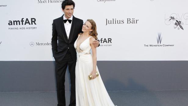 Kylie Minogue und ein Mann im Anzug posieren auf einer Veranstaltung von amfAR.