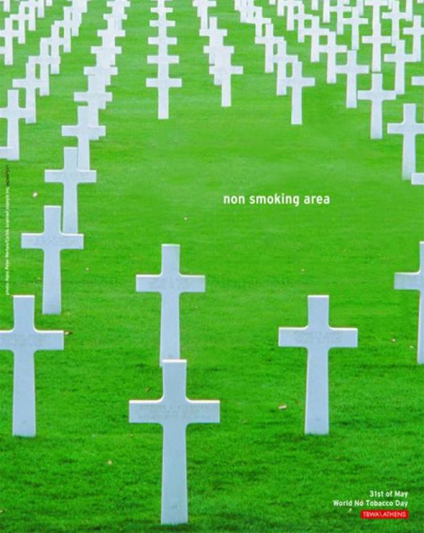 Ein Friedhof mit weißen Kreuzen auf einem grünen Rasen, der als Nichtraucherbereich ausgewiesen ist.