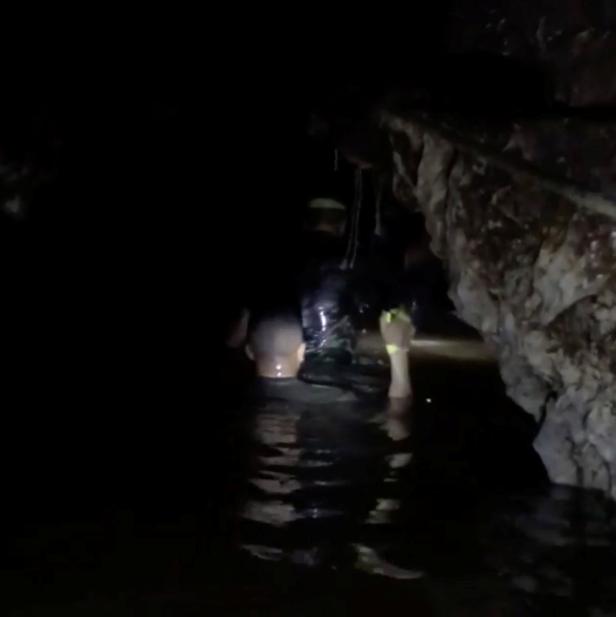 Rescuers wade in the flooded Tham Luang cave during a mission to evacuate the remaining members of a soccer team trapped in a flooded cave in Chiang Rai