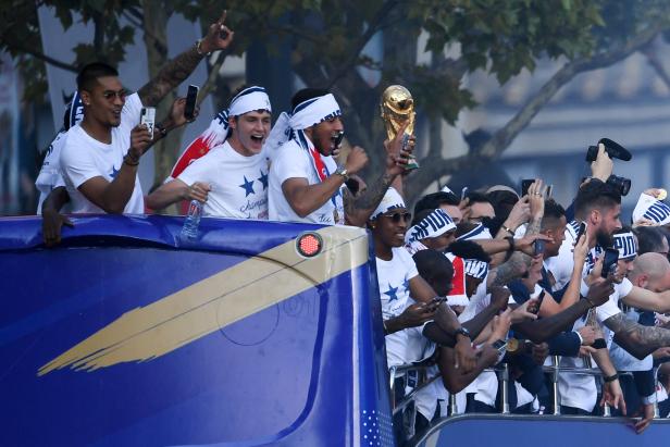 France's national team soccer players celebrate while parading down the Champs-Elysee avenue in Paris