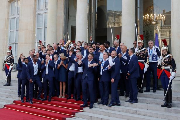 French President Emmanuel Macron and his wife Brigitte Macron pose with France soccer team captain Hugo Lloris holding the trophy, coach Didier Deschamps and players before a reception to honour the France soccer team at the Elysee Palace in Paris