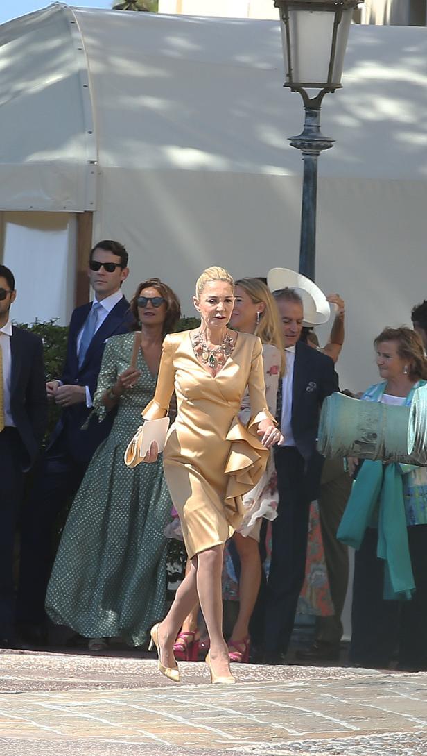 Eine Frau in einem goldenen Kleid verlässt eine Veranstaltung.