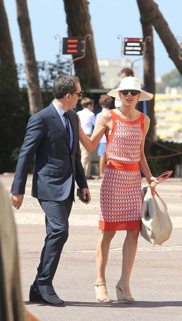 Fürstin Charlène von Monaco mit einem Mann in einem Anzug unterwegs.