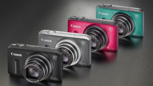 Vier Canon PowerShot SX260 HS Kameras in Schwarz, Grau, Pink und Türkis stehen aufgereiht.