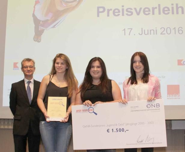 Drei junge Frauen und ein Mann posieren mit einer Urkunde und einem Scheck über 1.500 Euro bei einer Preisverleihung.