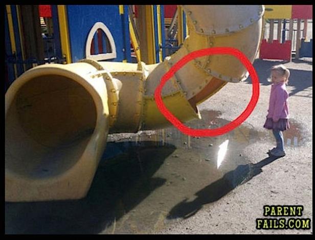 Ein Mädchen steht vor einer nassen Rutsche auf einem Spielplatz.