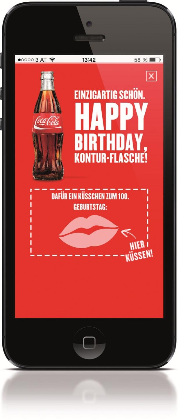 Coca-Cola, Mobile-Promotion Kiss - Image 4 - Digitalsunray Auf dem Smartphone-Bildschirm ist eine Coca-Cola-Geburtstagsanzeige zu sehen.