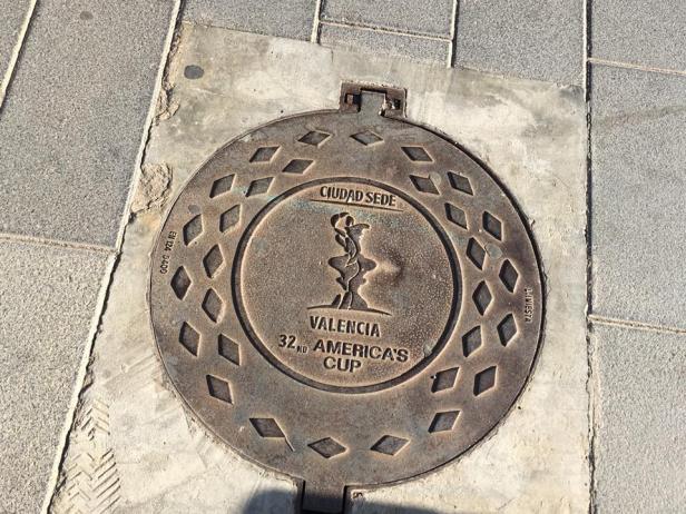 Ein Kanaldeckel in Valencia mit dem Logo des 32. America's Cup.