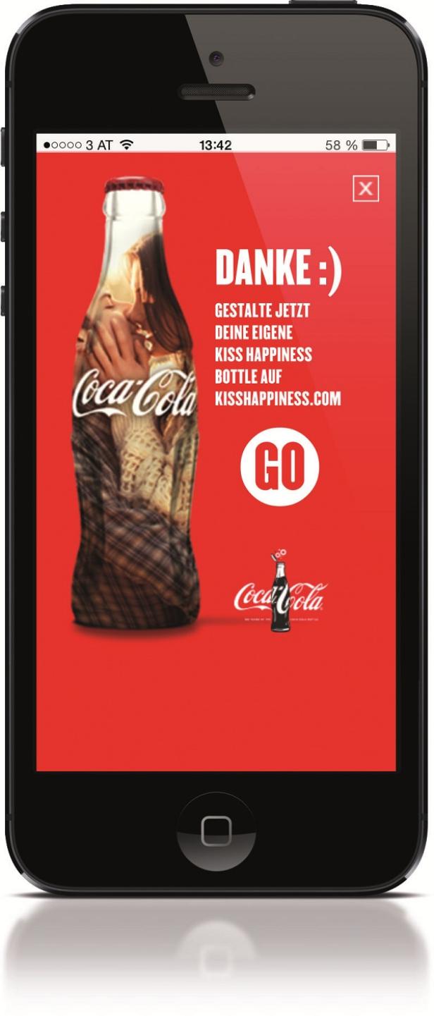 Coca-Cola, Mobile-Promotion Kiss - Image 2 - Digitalsunray Auf dem Bildschirm eines Smartphones ist eine Coca-Cola-Werbung mit dem Slogan „Kiss Happiness“ zu sehen.