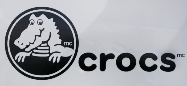 Das Logo der Marke Crocs mit einem Krokodil in einem Kreis.