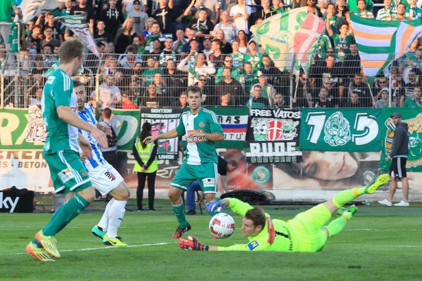Ein Fußballspiel mit einem Torwart, der versucht, einen Ball zu halten, und Zuschauern im Hintergrund.