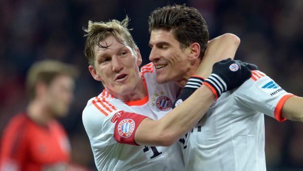 Bastian Schweinsteiger umarmt Mario Gomez während eines Fußballspiels.