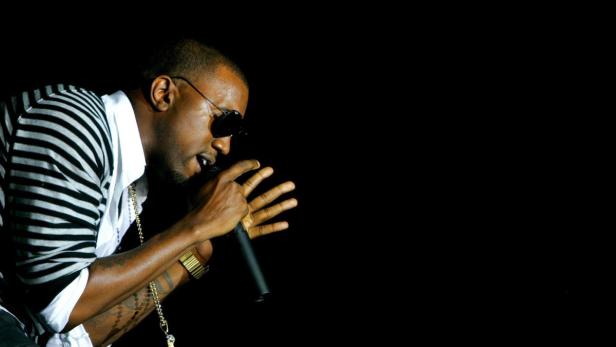 Ein Mann mit Sonnenbrille singt in ein Mikrofon.