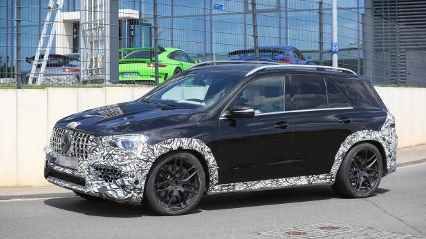 Ein schwarzer Mercedes-Benz GLE mit Tarnmuster fährt auf einer Straße.