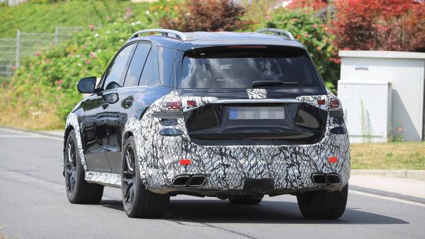 Ein schwarzer Mercedes-Benz SUV mit Tarnmuster fährt auf einer Straße.