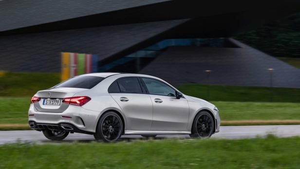 Eine silberne Mercedes-Benz A-Klasse Limousine fährt auf einer Straße.