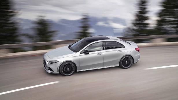 Eine silberne Mercedes-Benz A-Klasse Limousine fährt auf einer Landstraße.