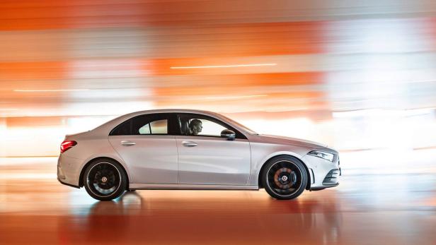 Eine silberne Mercedes-Benz A-Klasse Limousine fährt auf einer Straße.