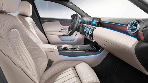 Innenraum eines Autos mit beigen Ledersitzen und blauer Ambientebeleuchtung.