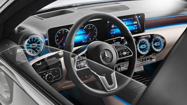Das Interieur eines Mercedes-Benz mit blau beleuchteten Lüftungsdüsen und einem digitalen Armaturenbrett.