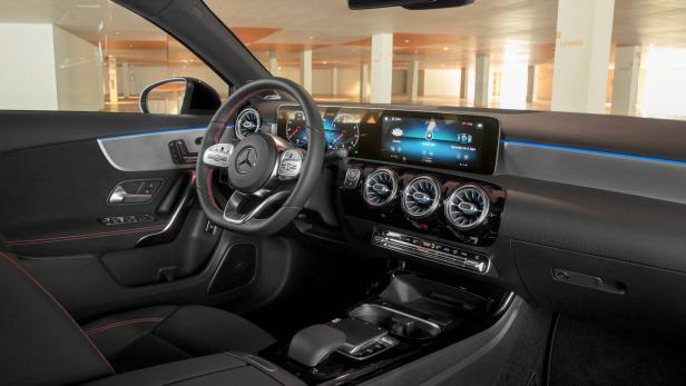 Das Interieur eines Mercedes-Benz mit schwarzem Leder und roten Ziernähten.