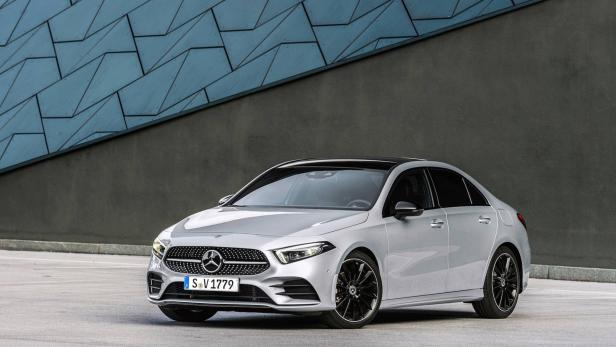 Eine silberne Mercedes-Benz A-Klasse Limousine vor einer grauen Wand.
