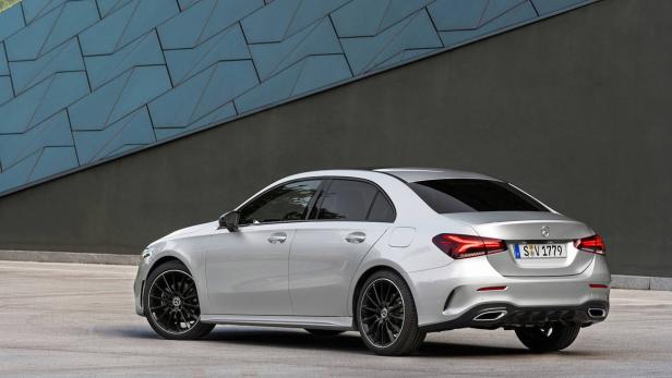 Eine silberne Mercedes-Benz A-Klasse Limousine vor einer Wand mit geometrischem Muster.