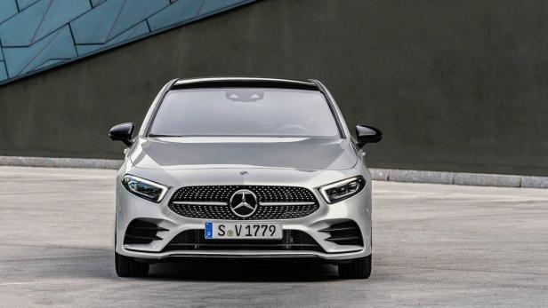 Ein silberner Mercedes-Benz steht vor einer grauen Wand.