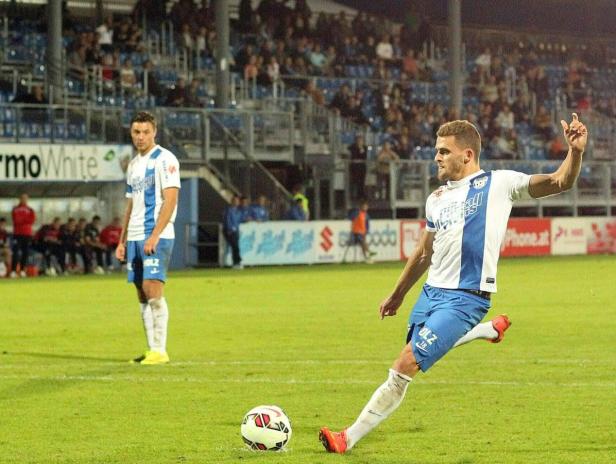 Ein Fußballspieler schießt den Ball während eines Spiels.