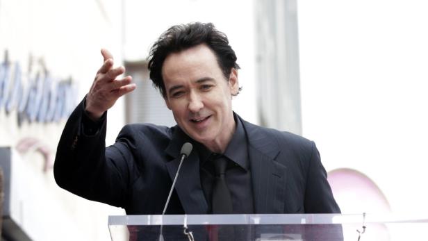 John Cusack gestikuliert bei einer Rede auf dem Hollywood Walk of Fame.