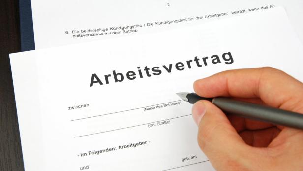 Ein Arbeitsvertrag wird mit einem Füllfederhalter unterschrieben.